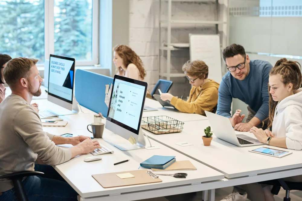 Personas colaborando alrededor de una mesa de trabajo